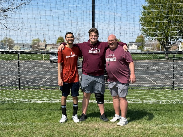 Aaron, Michael, and Coach in front of soccer goal